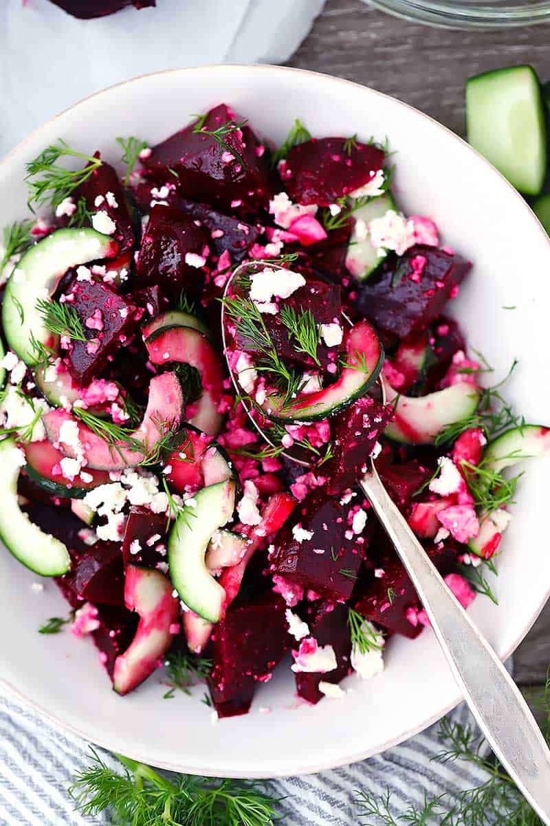 Overhead photo of a spoon in beet, cucumber, and feta salad.