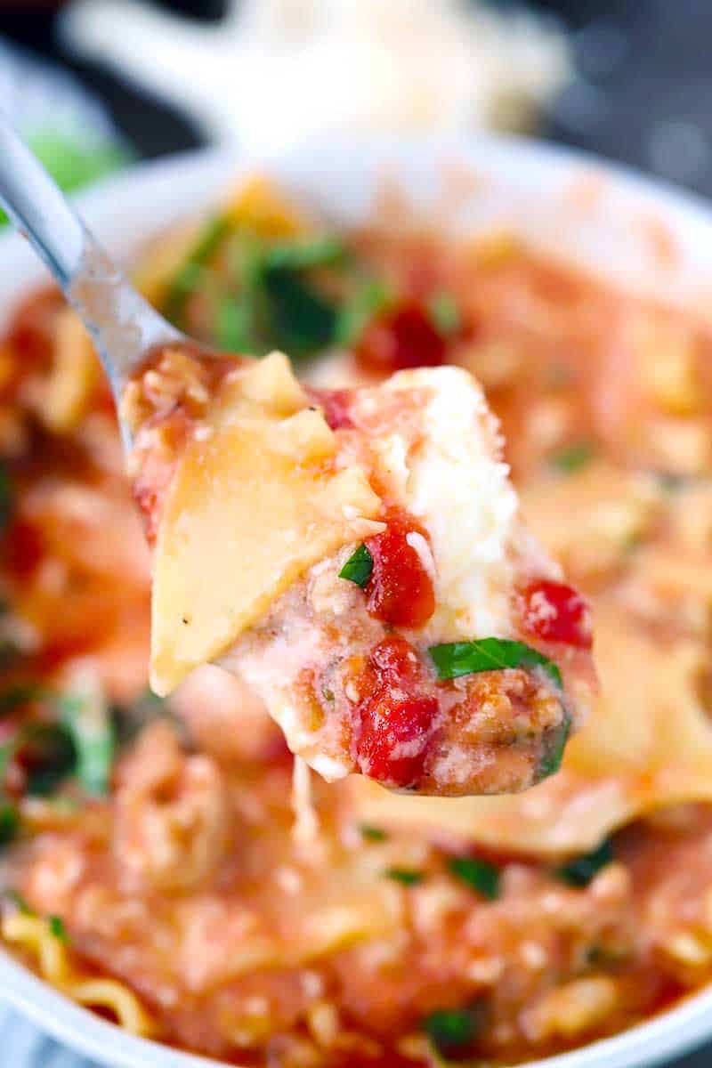 A spoonful of lasagna soup with noodles and ricotta cheese.