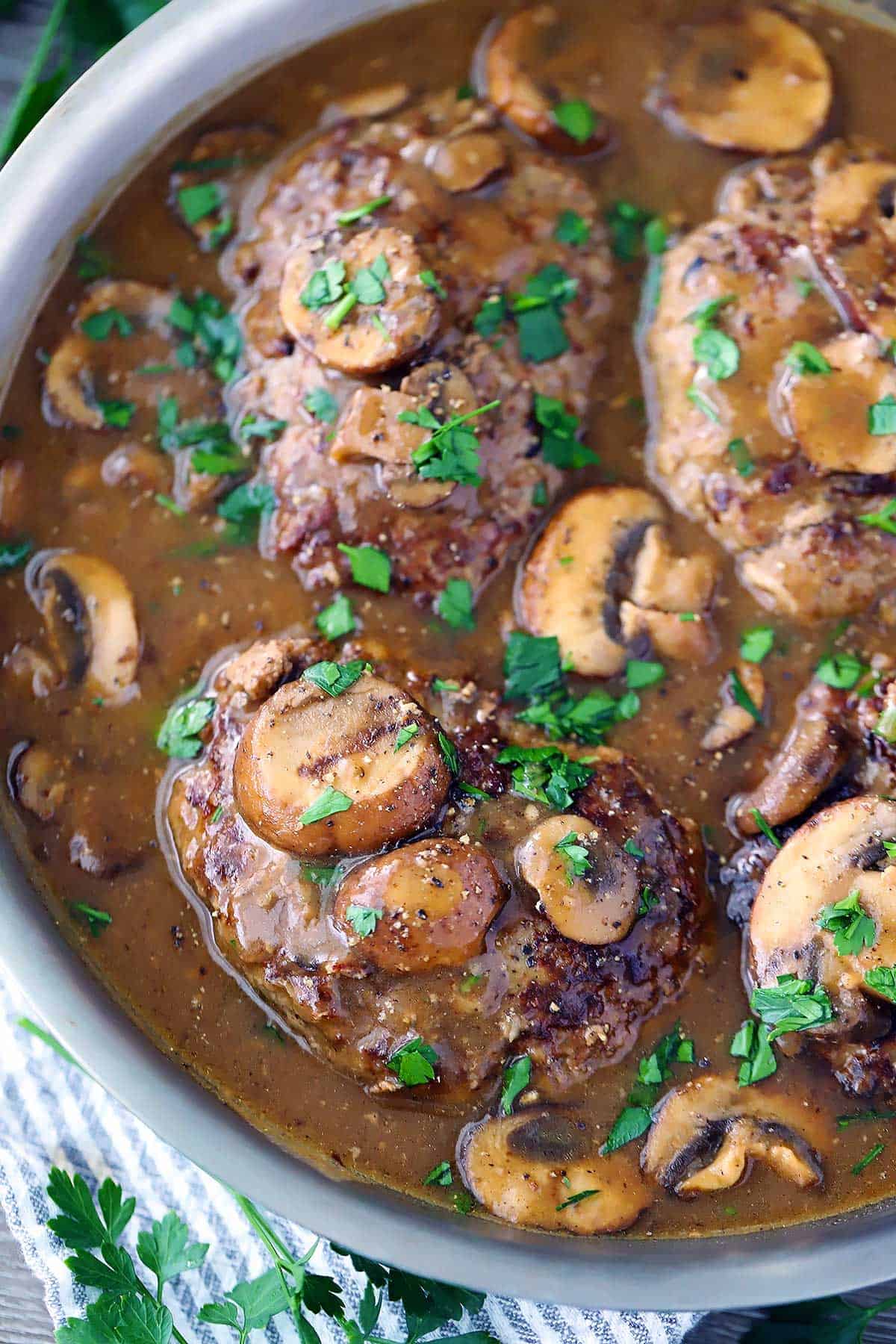 salisbury steak with mushroom gravy in a skillet.