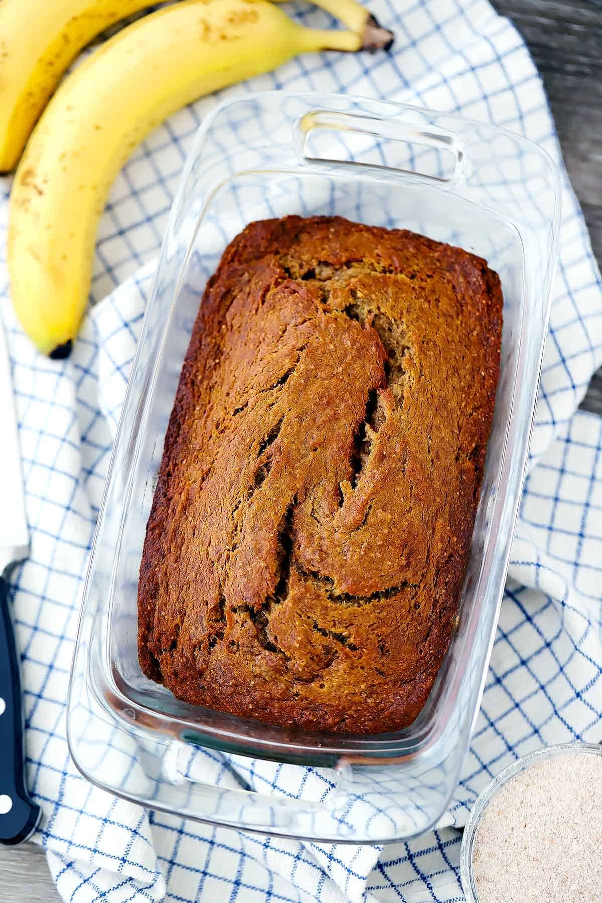 A loaf of healthy banana bread in a glass loaf pan.