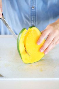 Cutting down the sides of a mango.