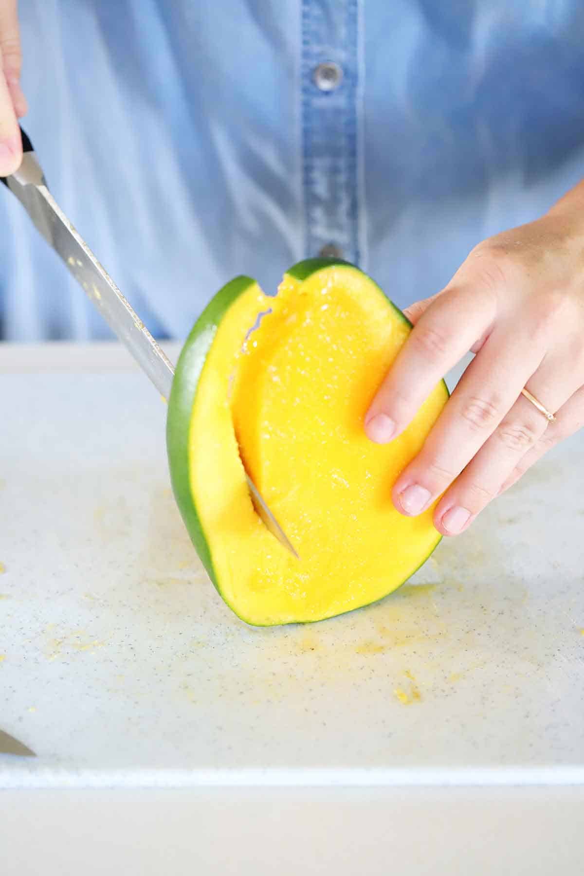 Cutting down the sides of a mango.