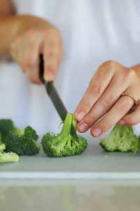 Slicing a floret of broccoli in half.
