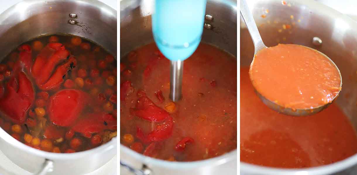 Using an immersion blender to puree roasted red pepper and tomato soup in a large pot.