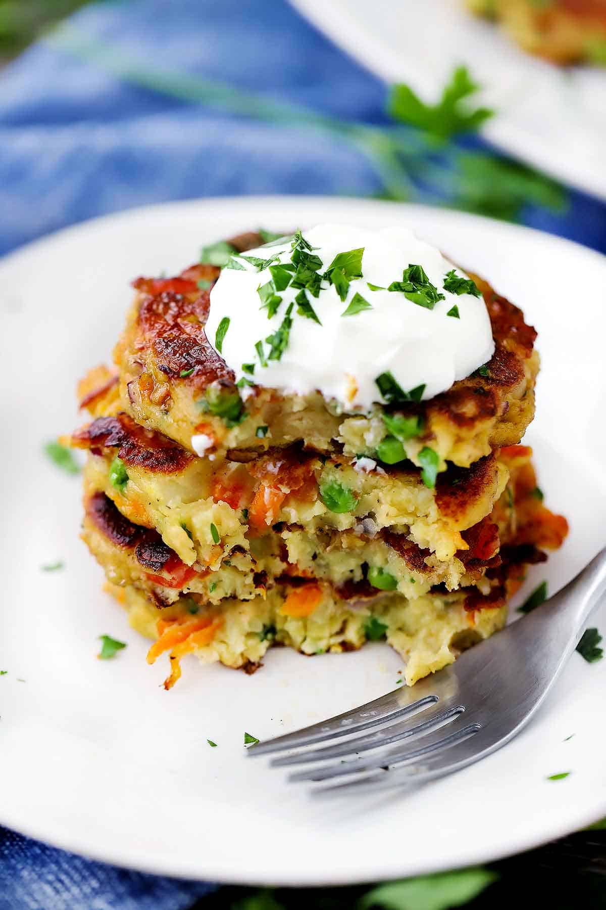 A stack of leftover mashed potato cakes with a bite taken out.