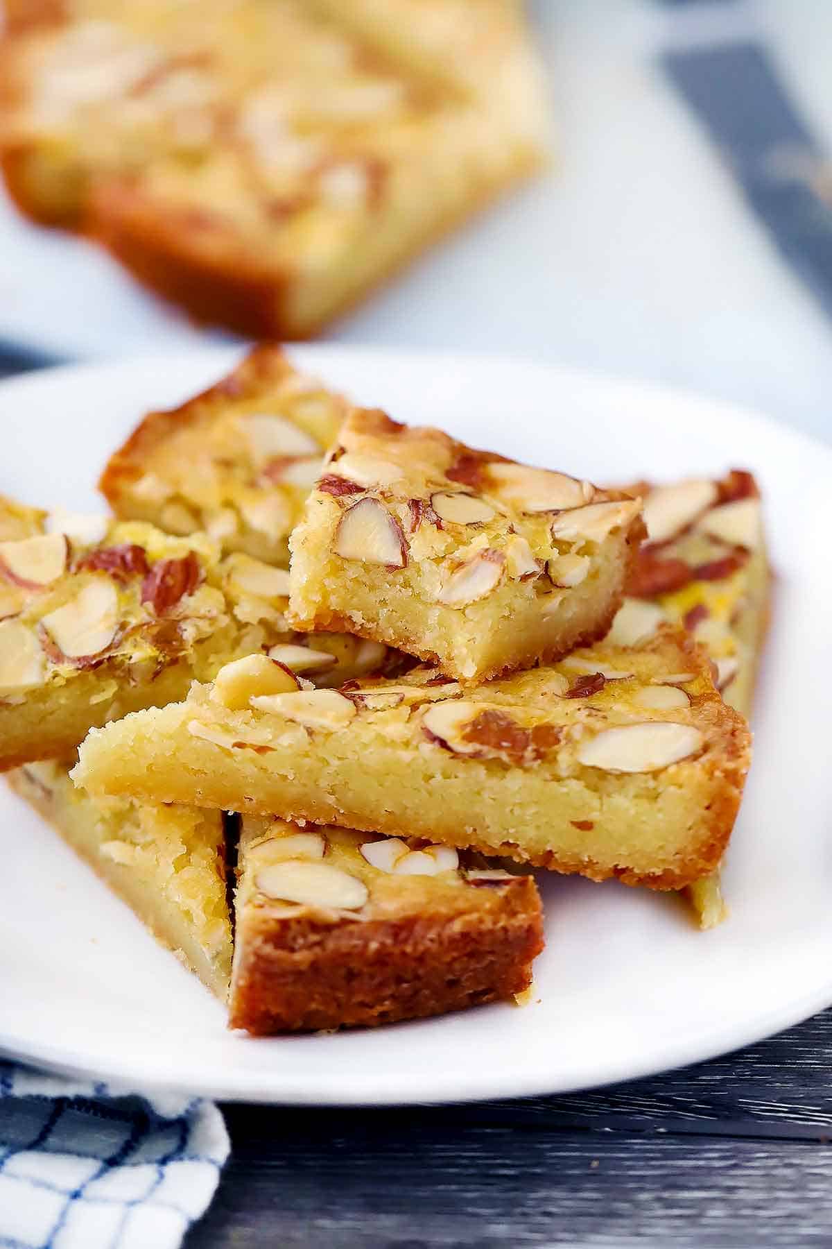 A plate with triangles of Dutch Butter Cake, or boterkoek, with a bite taken out of one.