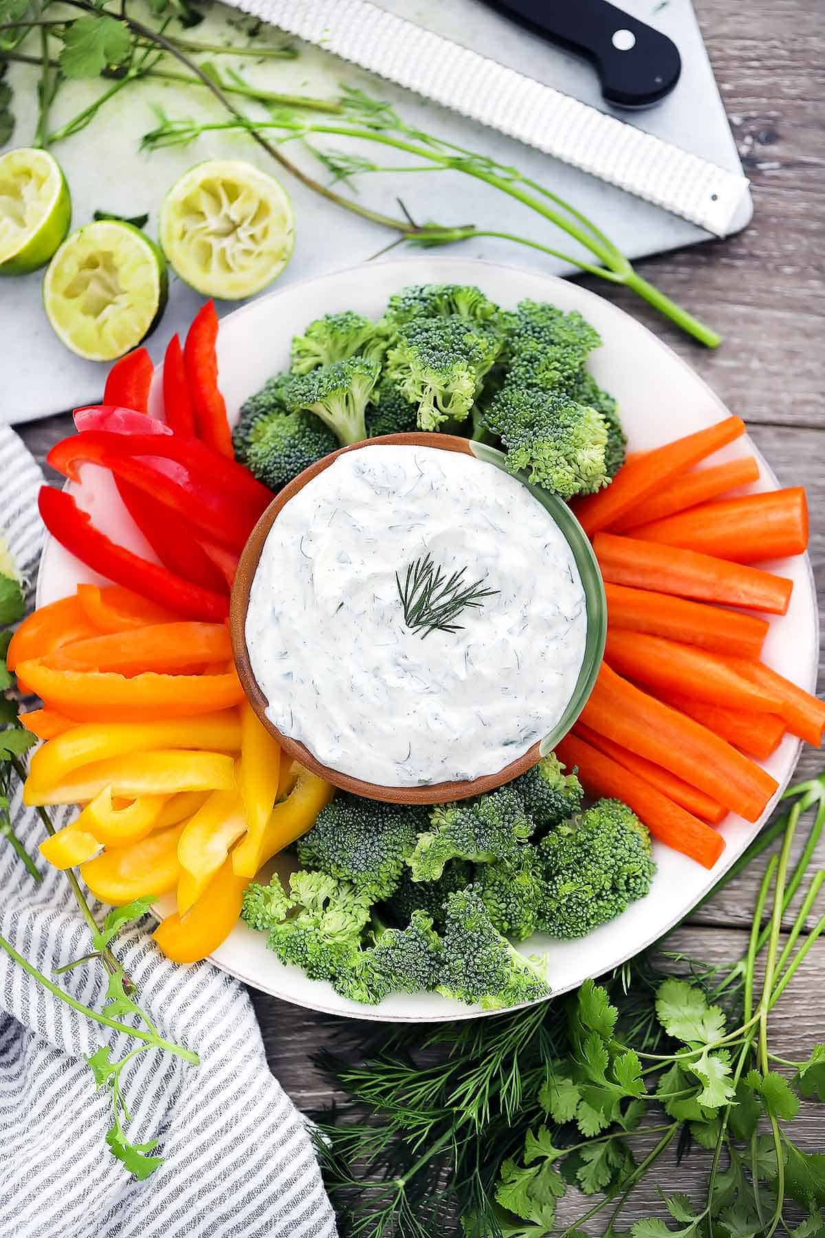 Overhead photo of a plate of cut up vegetables with dill dip.