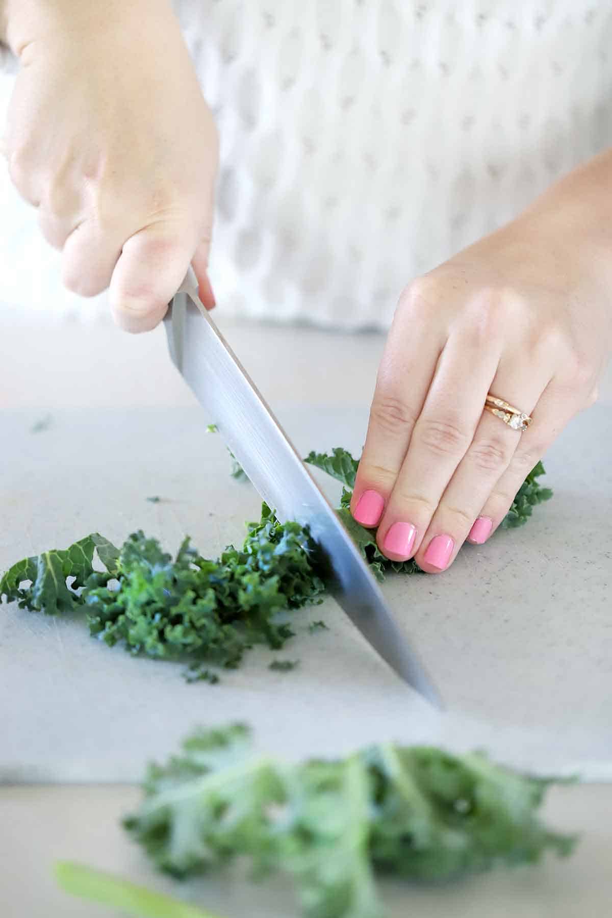Chopping kale on a cutting board.