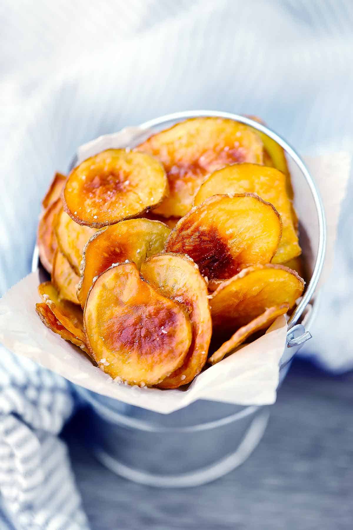 Homemade baked potato chips in a bucket.