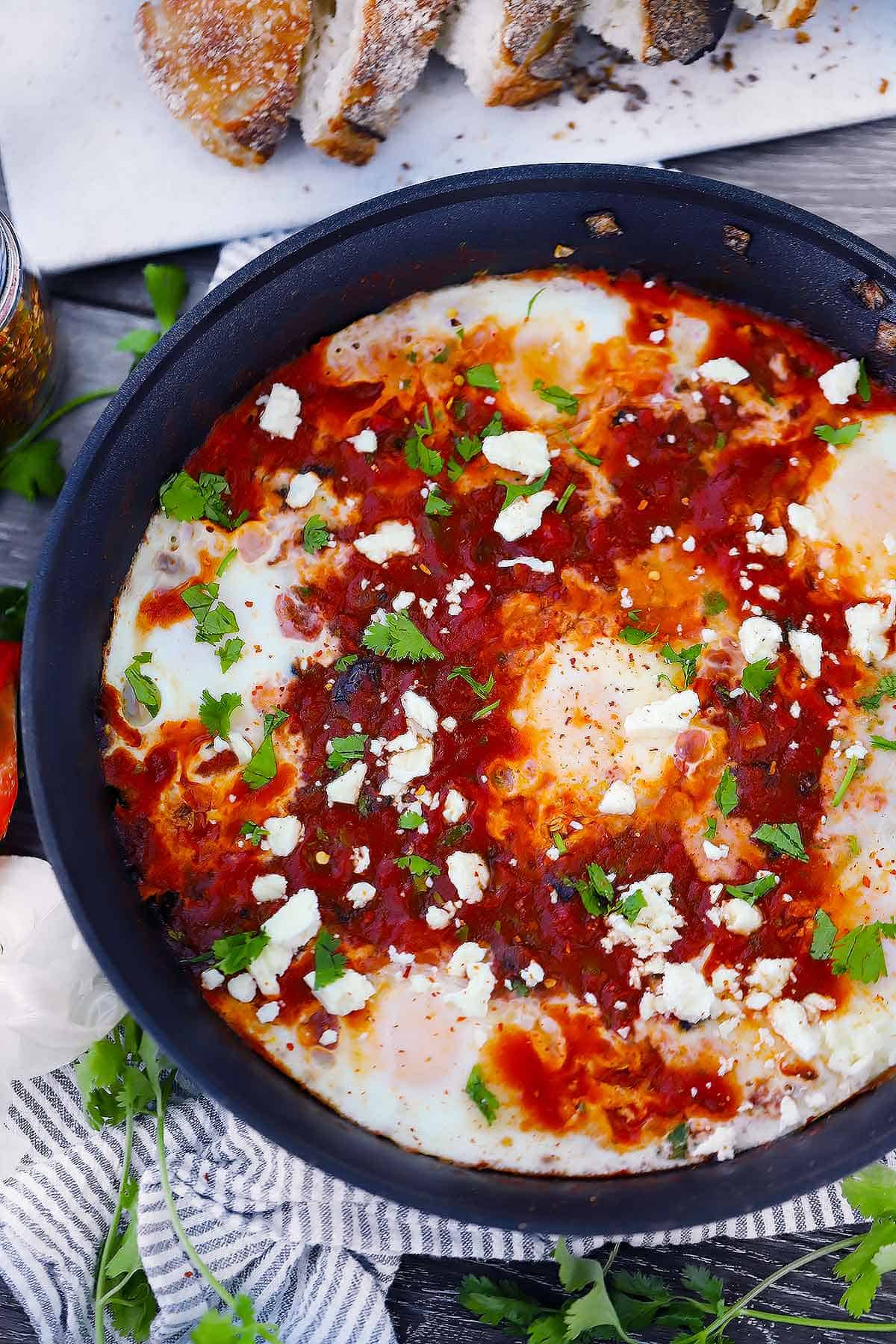 A skillet with shakshuka and feta sprinkled on top.