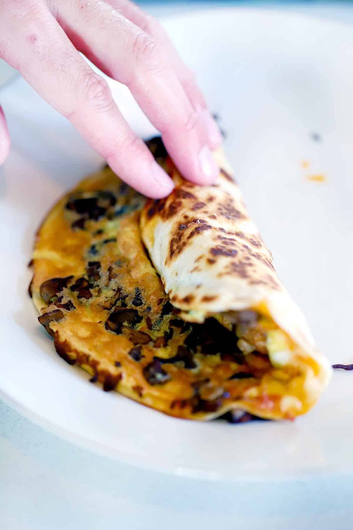 Rolling up a tortilla egg wrap.