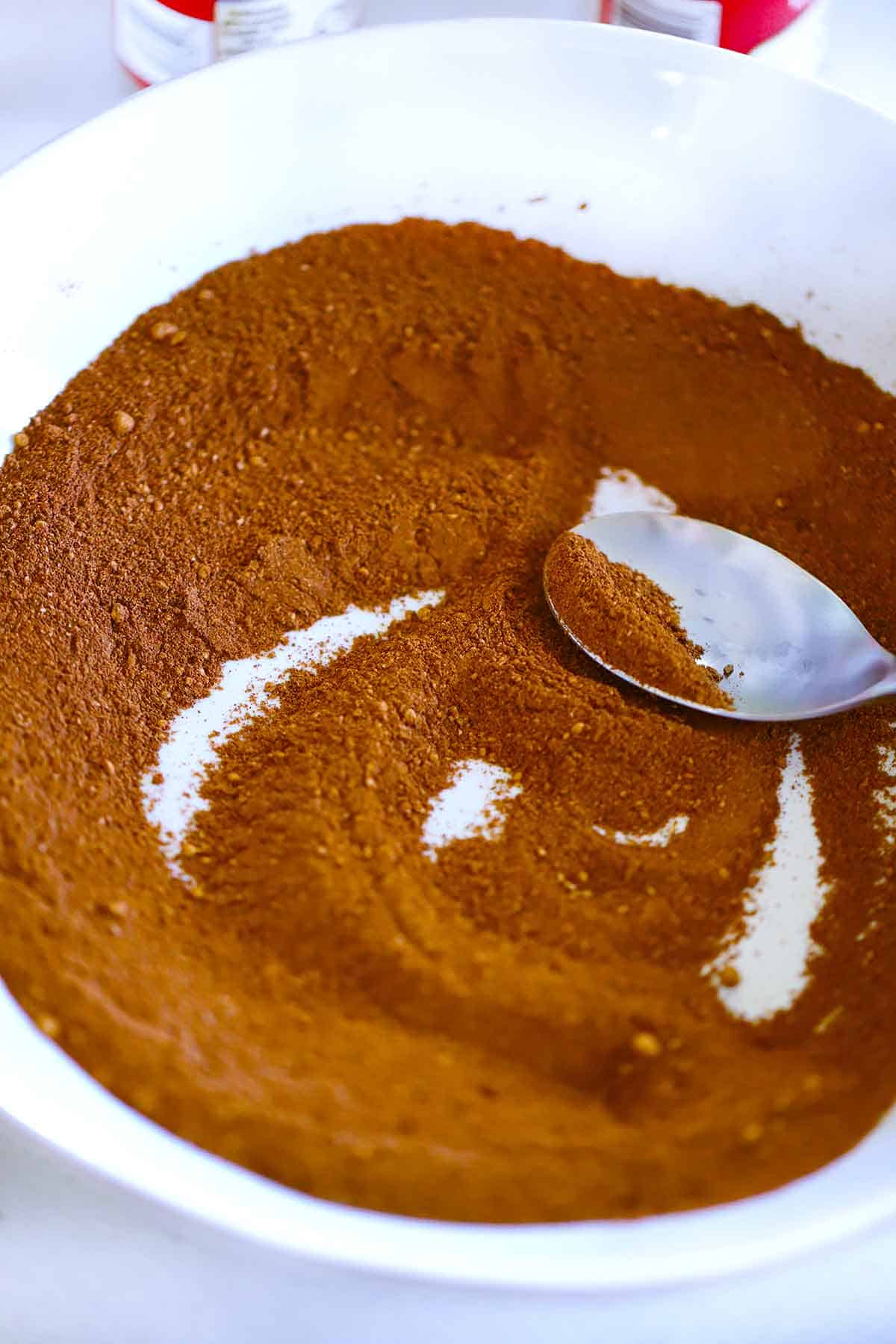 Mixing homemade pumpkin spice in a bowl with a spoon.