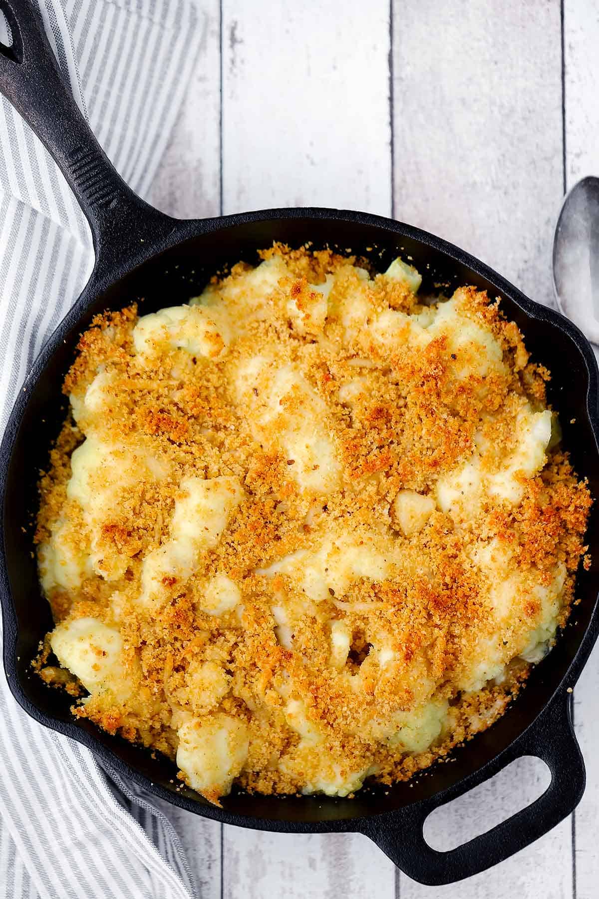 Overhead photo of cauliflower gratin with breadcrumb topping in a cast iron skillet.