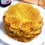Square photo of heart shaped Norwegian waffles on a white plate.