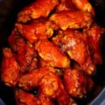 Square photo of buffalo wings in a slow cooker.