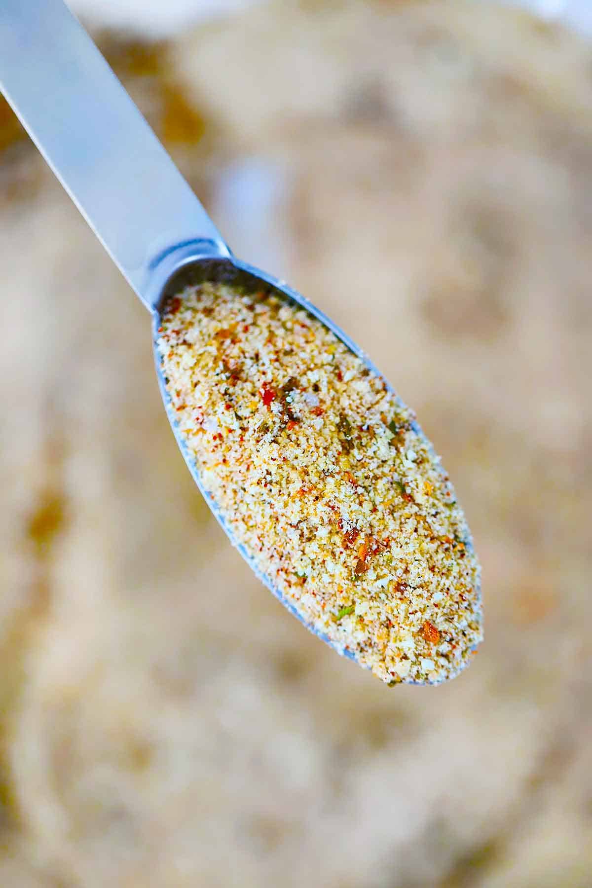 A measuring spoon filled with Italian bread crumbs (close up photo).