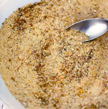 A close up photo of Italian Seasoned Bread Crumbs mixed together with a spoon.
