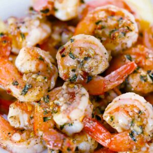 Square photo of sauteed shrimp with garlic and herbs.