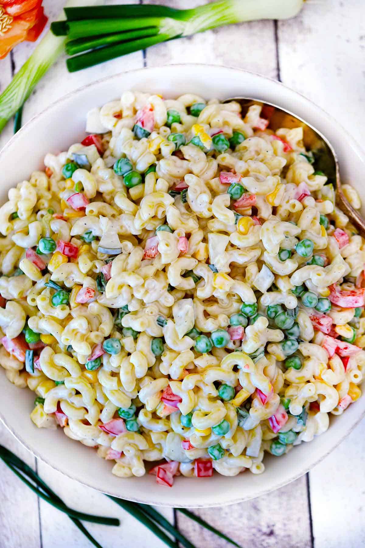Overhead photo of macaroni salad with vegetables in a white bowl.