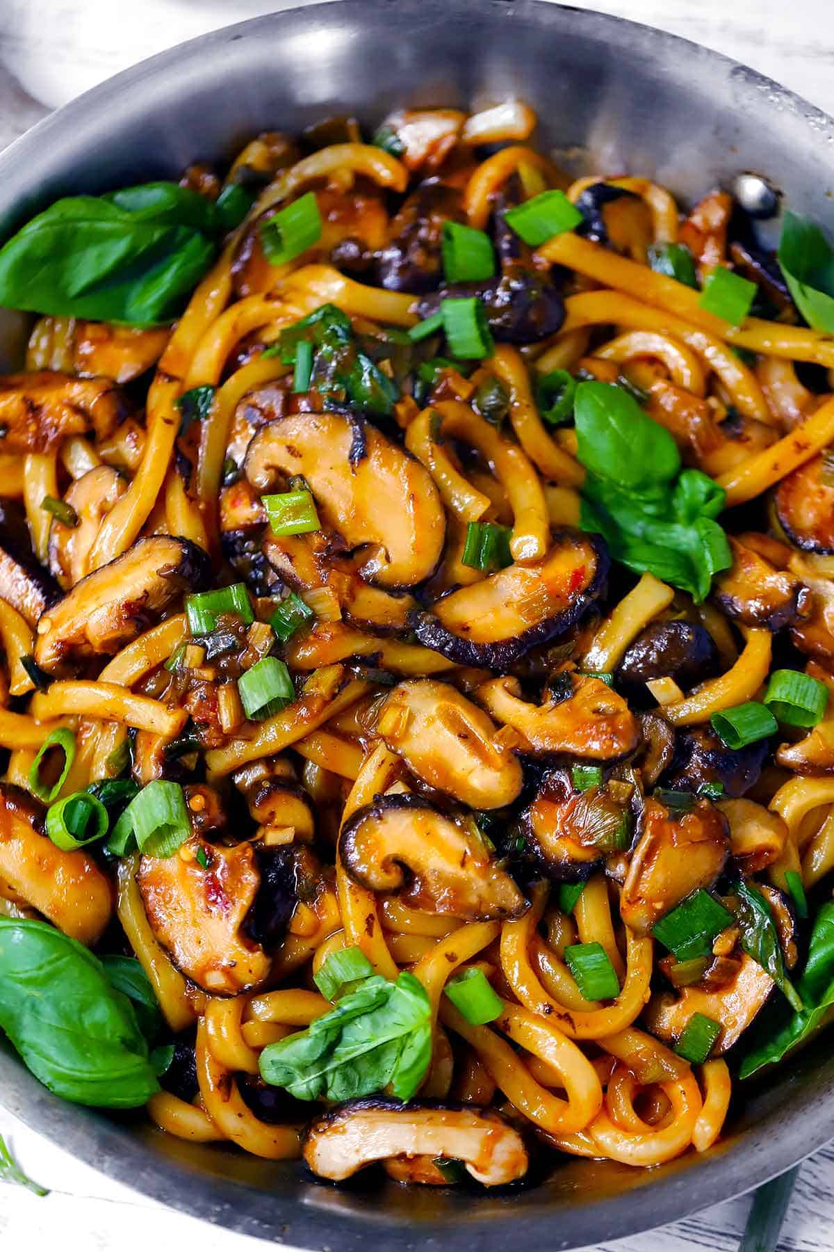 Close up overhead photo of a skillet with Udon Noodle stir fry in it.