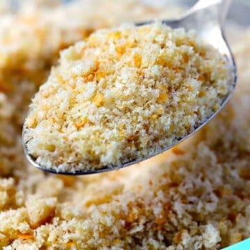 Close up square photo of a spoon scooping homemade bread crumbs.