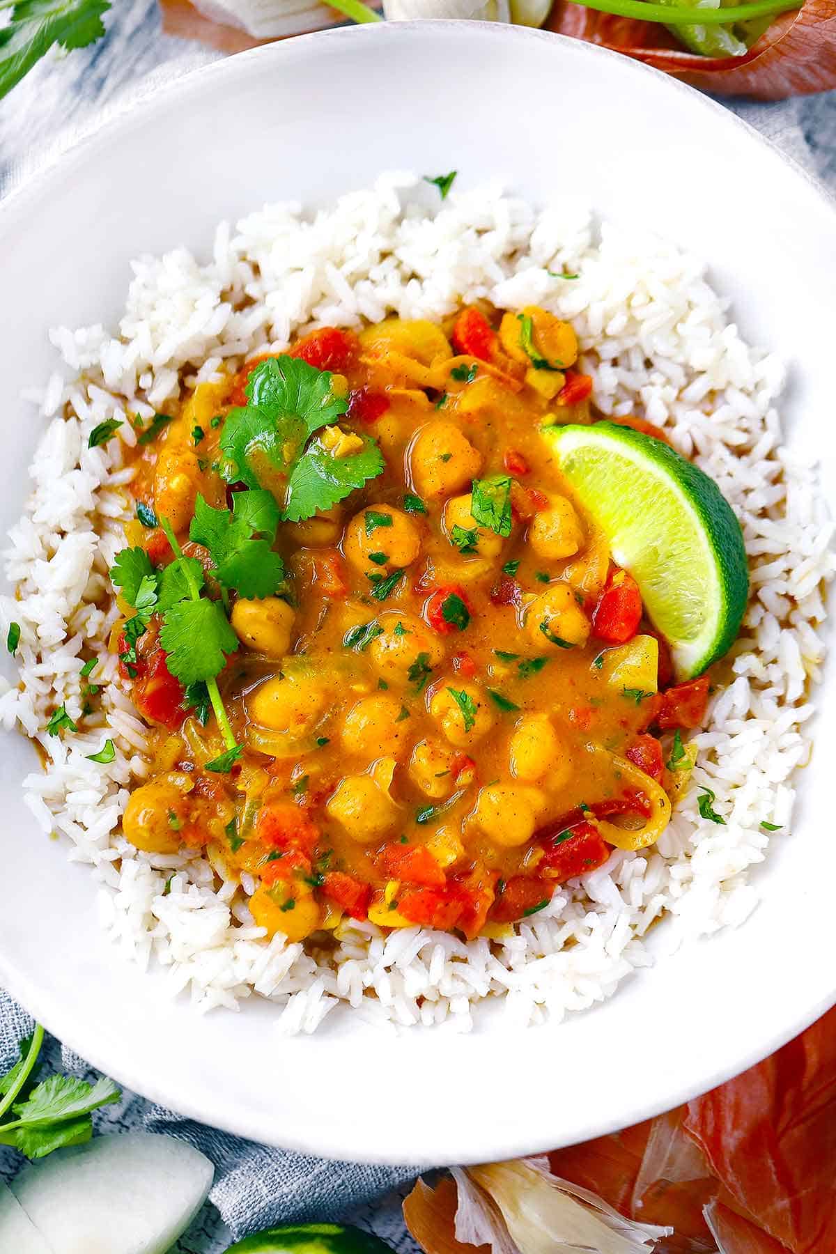 Close up photo of chickpea curry in a white bowl over rice.