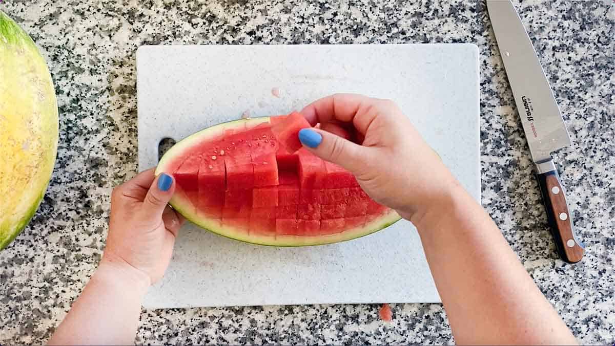 Removing a cube from a watermelon quarter.