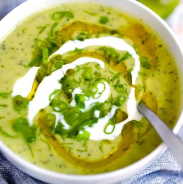 Square photo of zucchini soup in a bowl.
