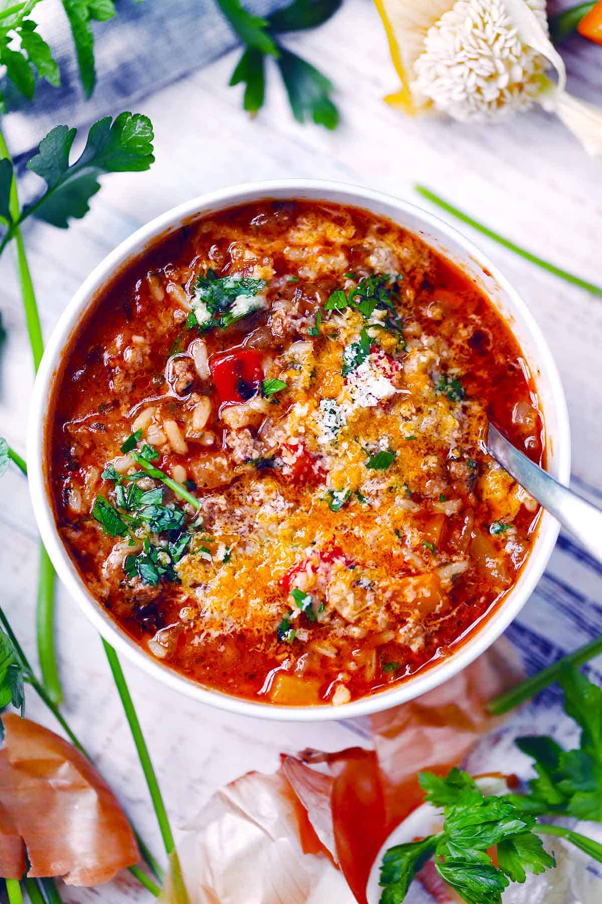 Overhead photo of a bowl of stuffed pepper soup with a spoon in it.