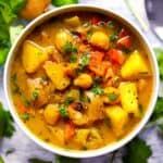 Square photo of a bowl of chickpea potato curry soup.