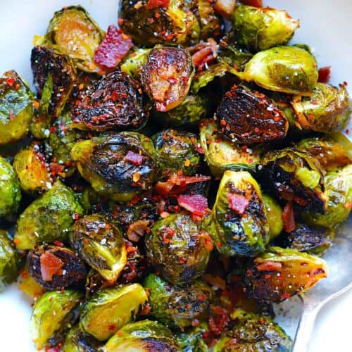 Square photo of overhead view of roasted brussels sprouts with maple syrup and bacon.